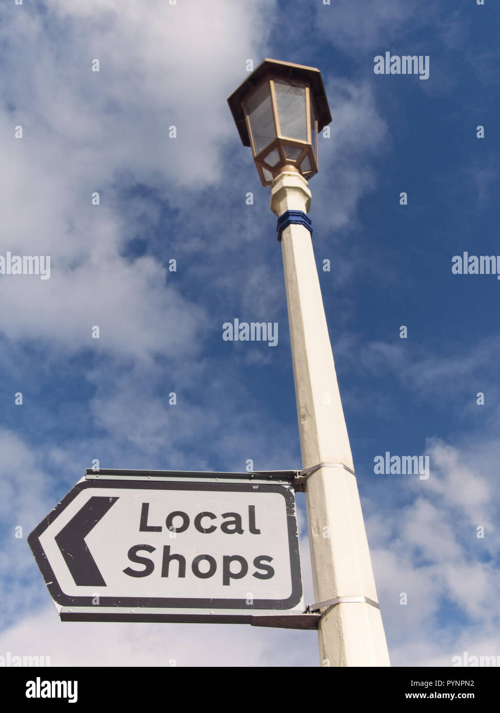 Englisch Straßenschild für die lokalen Geschäfte gegen den blauen Himmel mit Wolken Hintergrund. Stockfoto