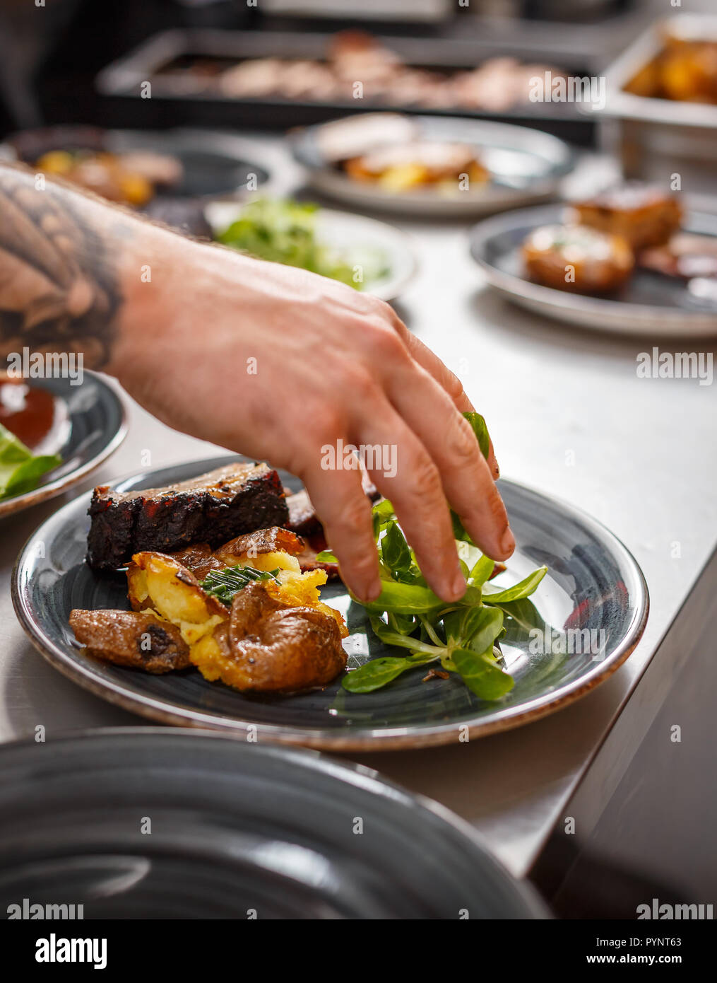 Koch plating Teller auf den Küchentisch, bevor sie an den Kunden dienen. Stockfoto