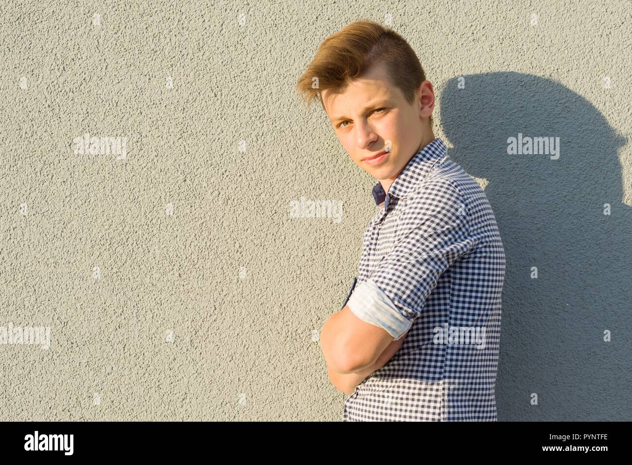 Outdoor Portrait von Teenage boy 14, 15 Jahre alt. Graue wand hintergrund, kopieren. Stockfoto