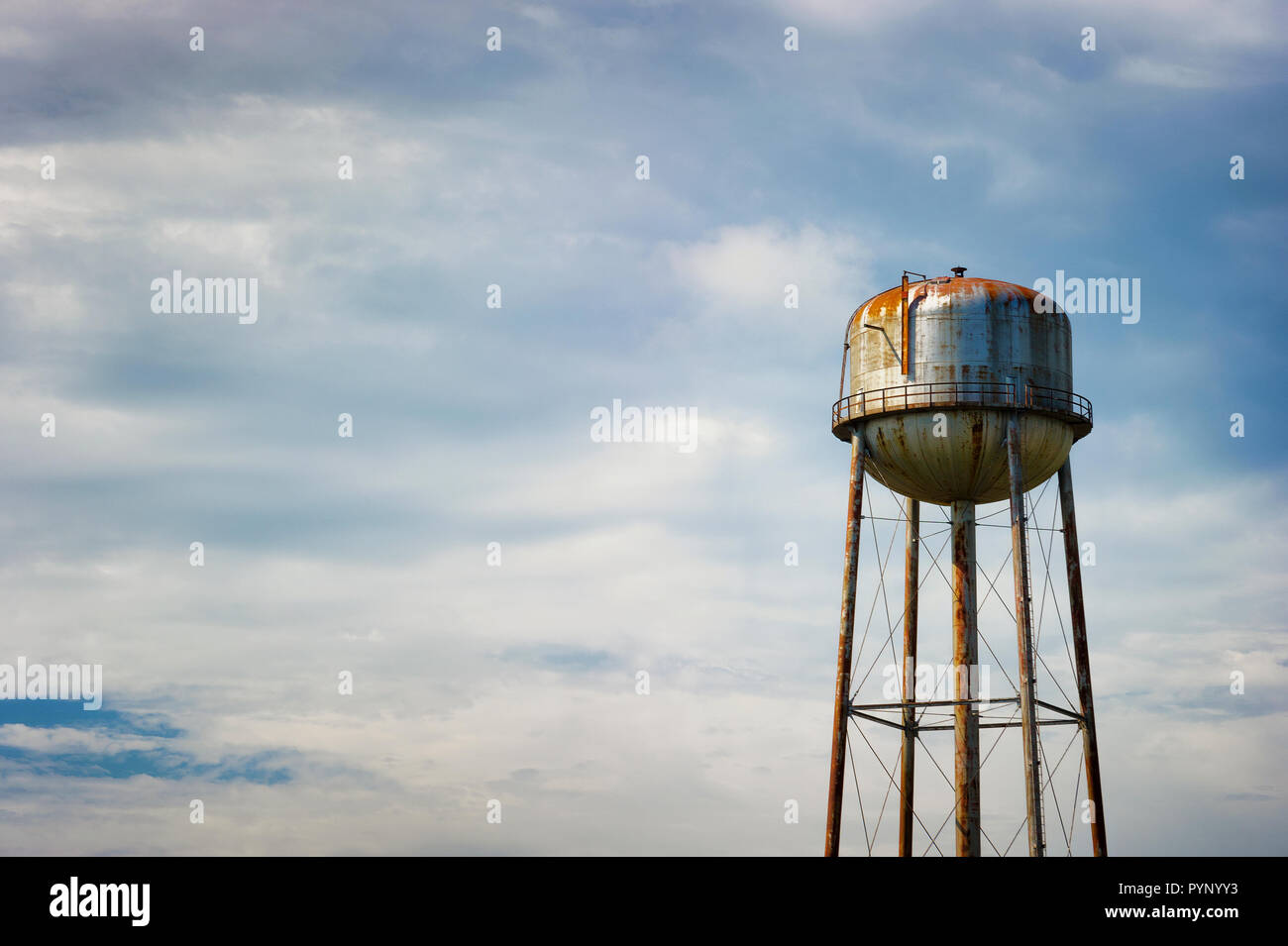 Kopieren der Platz in einem minimalistischen Fotografie ein rostiges Wasser turm bei bewölktem Himmel. Stockfoto