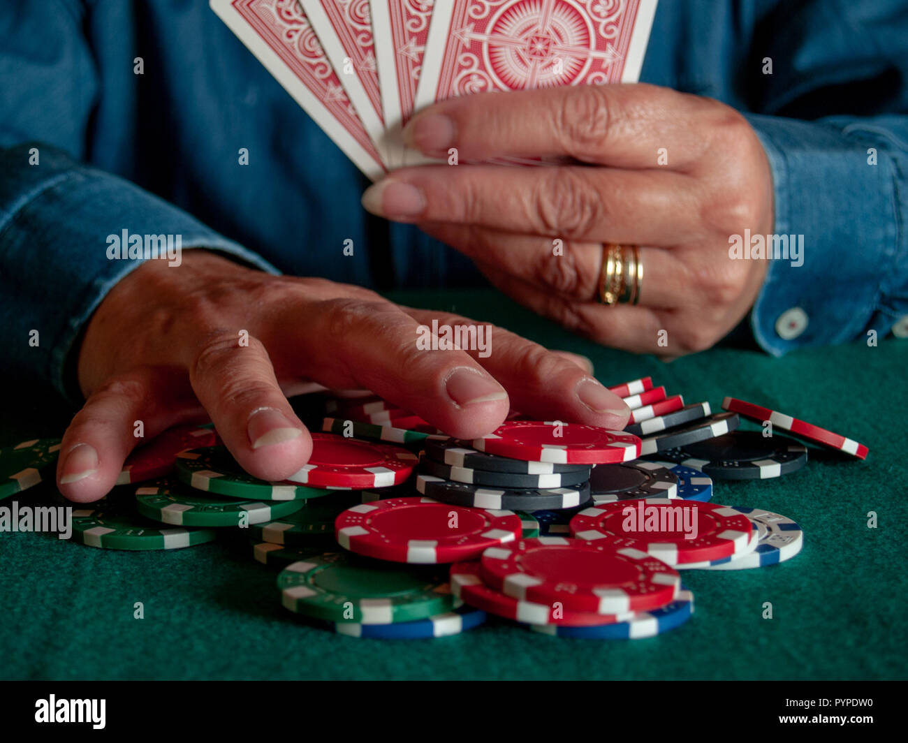 Eine Person spielen Poker Wetten poker chips in verschiedenen Farben Stockfoto