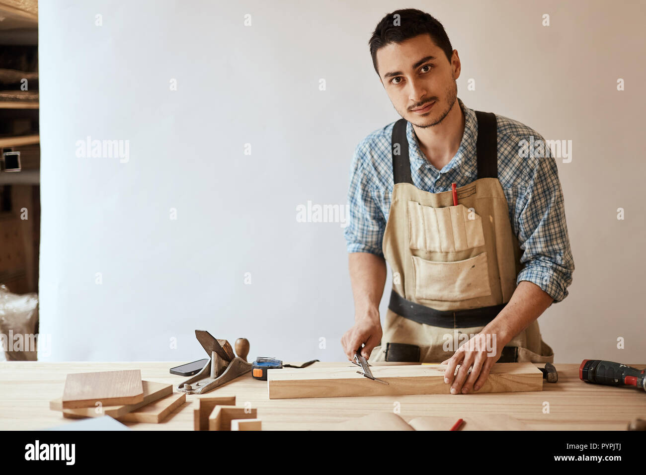 Hand eines Zimmermanns, die Messung einer Holzbohle Stockfoto