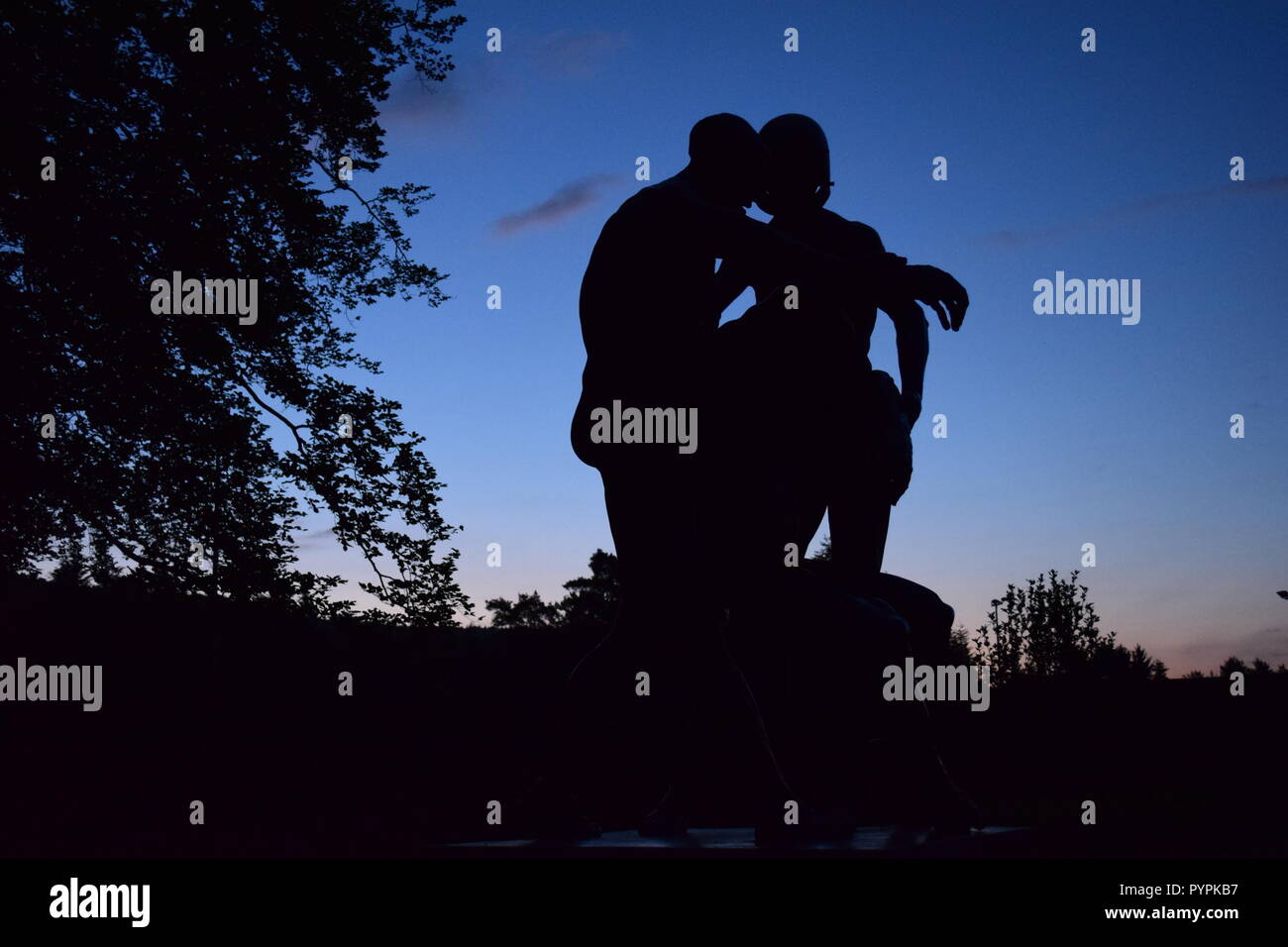 Bronze Skulptur gegen gegen eine morgendliche Dämmerung Himmel bei Sonnenaufgang Silhouette in den Soldatenfriedhof, Kriegerfriedhofstraße, in Reimsbach/Saar Stockfoto