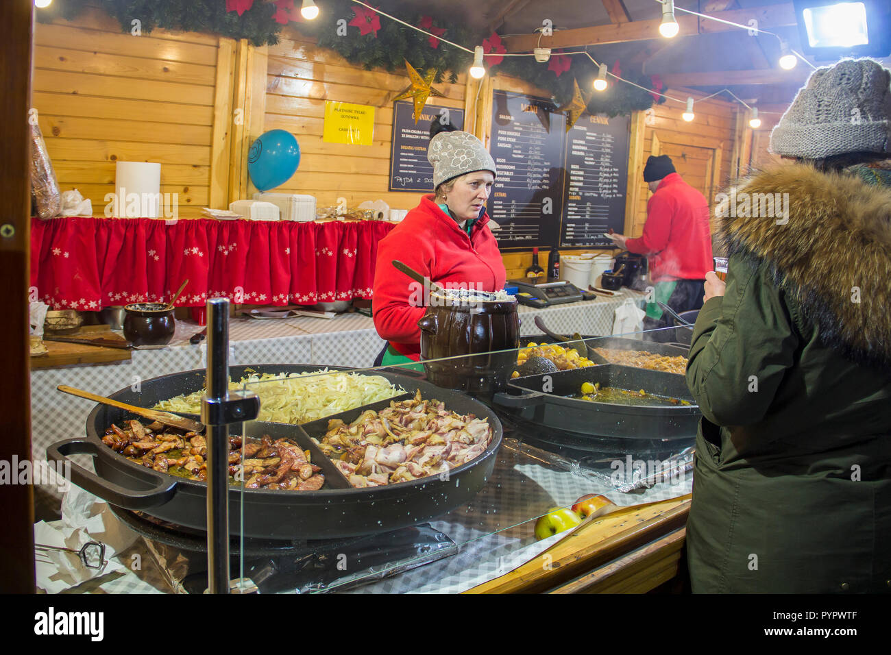 WROCLAW, Polen - 7. DEZEMBER 2017: Frau verkauft traditionelle polnische Speisen auf Winter Weihnachtsmarkt Stockfoto