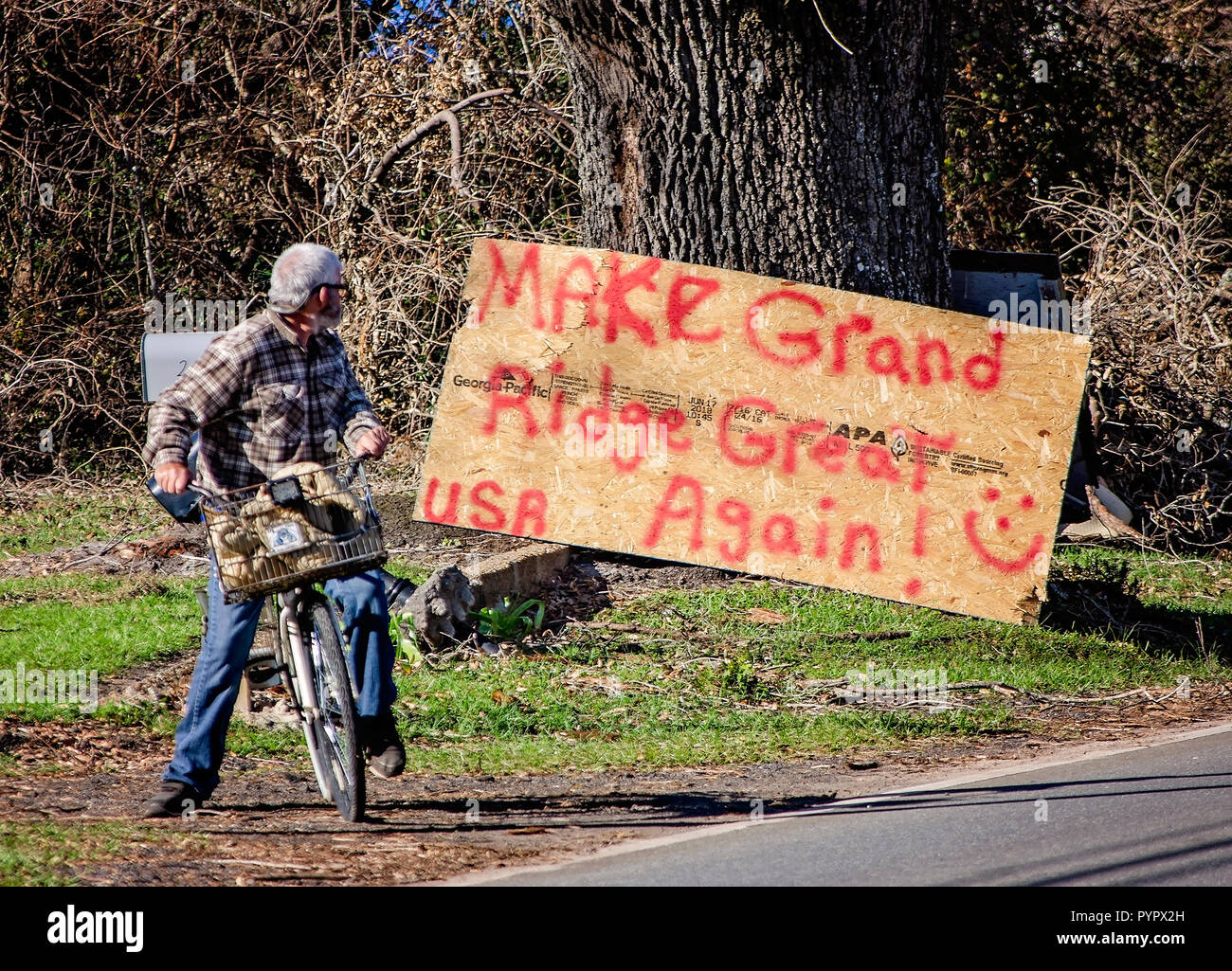 John Holland, 61, blickt auf ein handgemaltes Schild, 'Make Grand Ridge Wieder einmal Super, 'Nach dem Hurrikan Michael, Oktober 21, 2018, in großartigen Ridge, Florida. Stockfoto