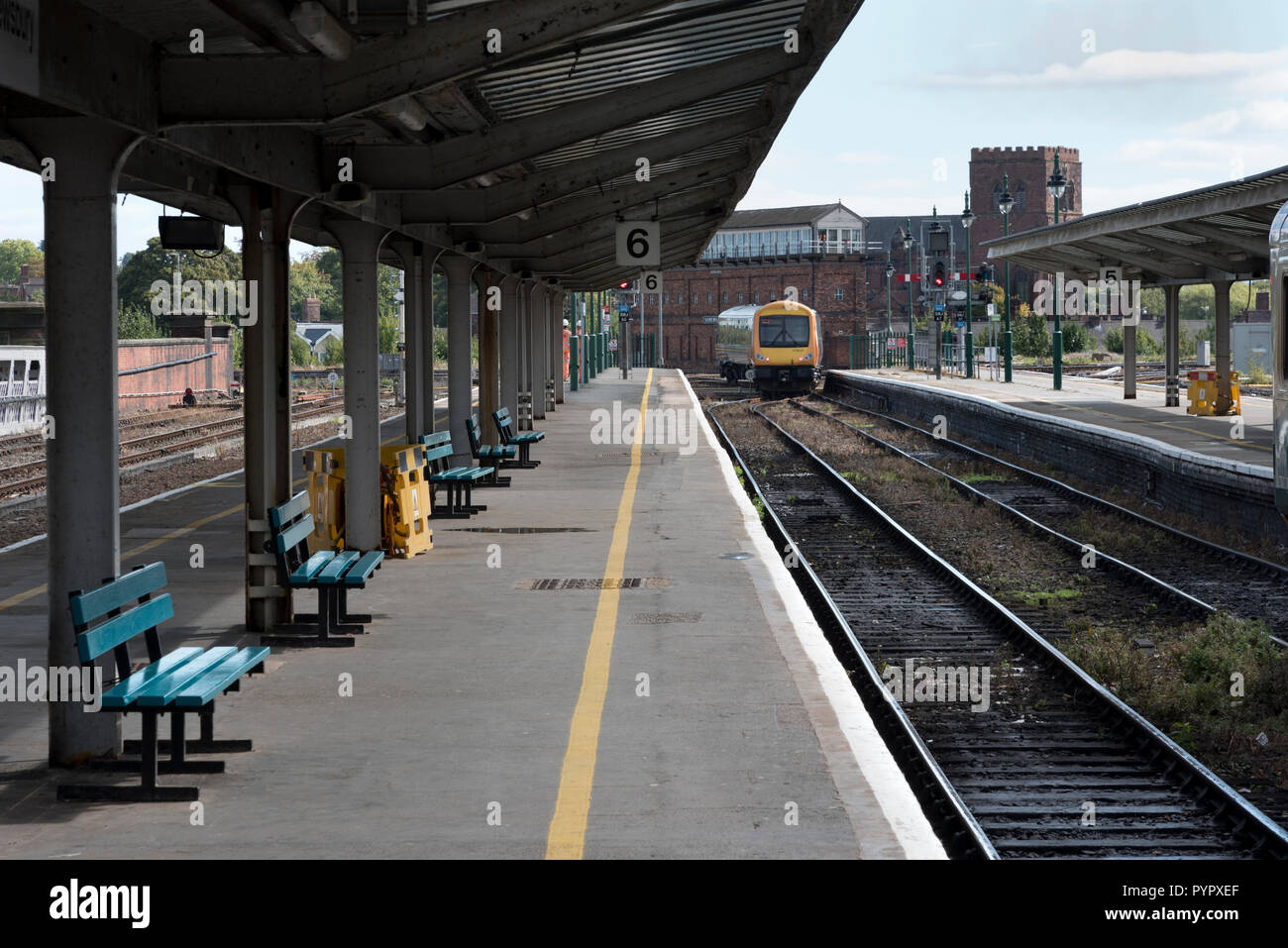 Ein Personenzug fährt vom Bahnhof Shrewsbury, Shropshire, Großbritannien. Shrewsbury Abbey kann im Hintergrund zu sehen ist, Stockfoto
