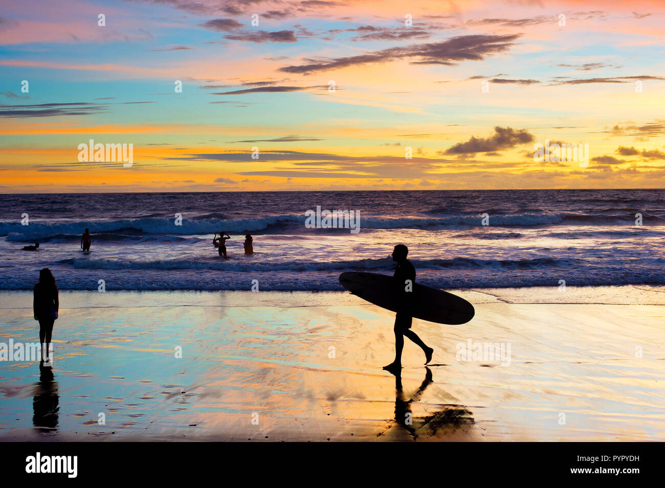 Mit dem Surfboard am Strand bei Sonnenuntergang Surfer. Die Insel Bali, Indonesien Stockfoto