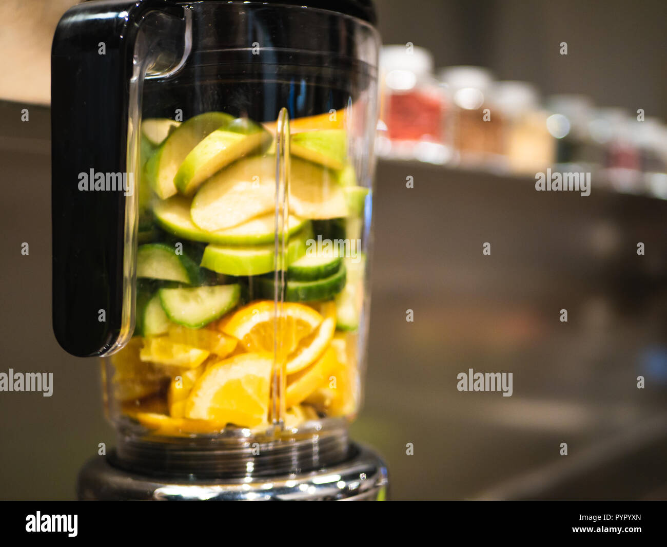 Mixer mit frischem Obst und Gemüse für eine grüne Smoothie - Orangen, Äpfel, Gurke Stockfoto
