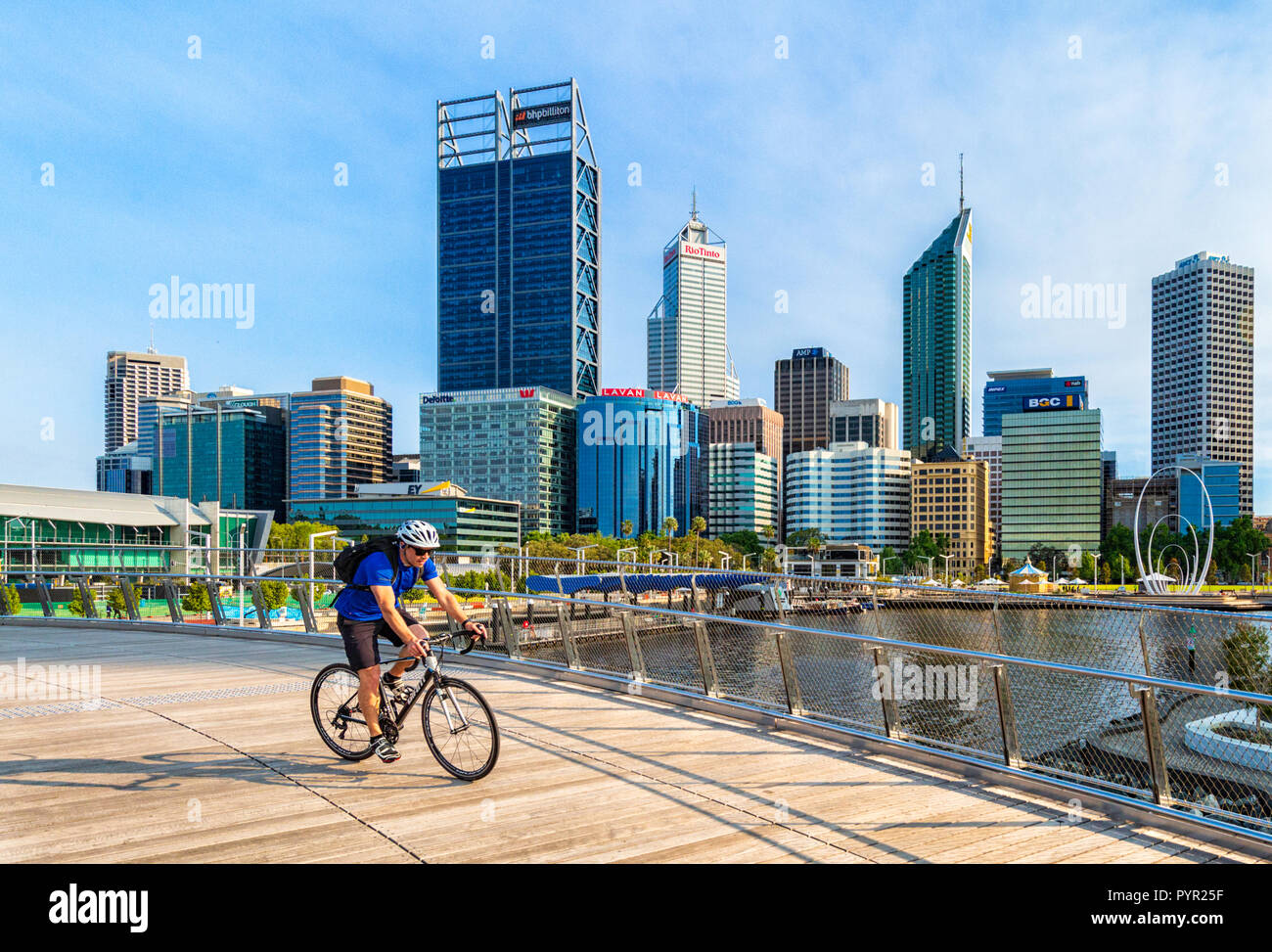 Ein Mann Radfahren über Elizabeth Quay Brücke mit Blick auf Perth City im Hintergrund. Elizabeth Street, Perth, Western Australia Stockfoto