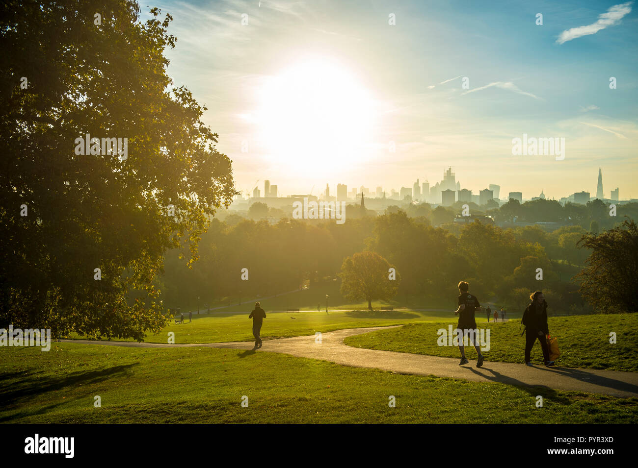 LONDON - ca. Oktober 2018: Jogger vor einem Sonnenaufgang Blick auf die Skyline der Stadt. Stockfoto