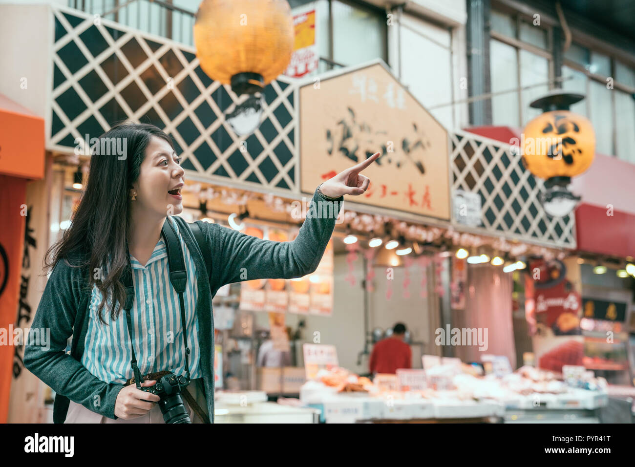 Touristische objektiv Mann an die Anbieter auf dem Markt: kuromon zeigen während Reisen jp. Junge Dame aufgeregt vor dem Speichern in der traditionellen St Stockfoto