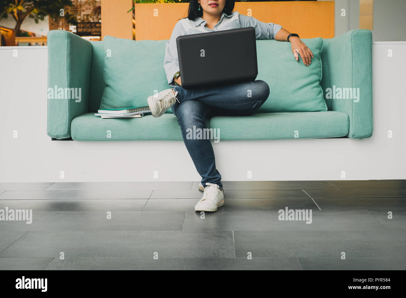 Studenten sitzen im Sofa und mit Laptop Computer eine Lektion online, E-Learning - Konzept zu studieren Stockfoto