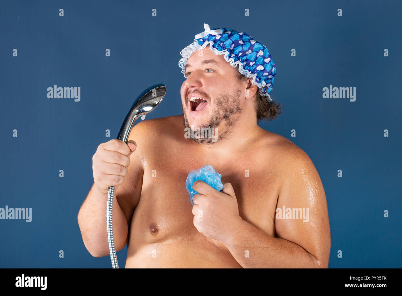 Funny fat man in blaue Kappe Singen in der Dusche. Spaß und Sauberkeit Stockfoto