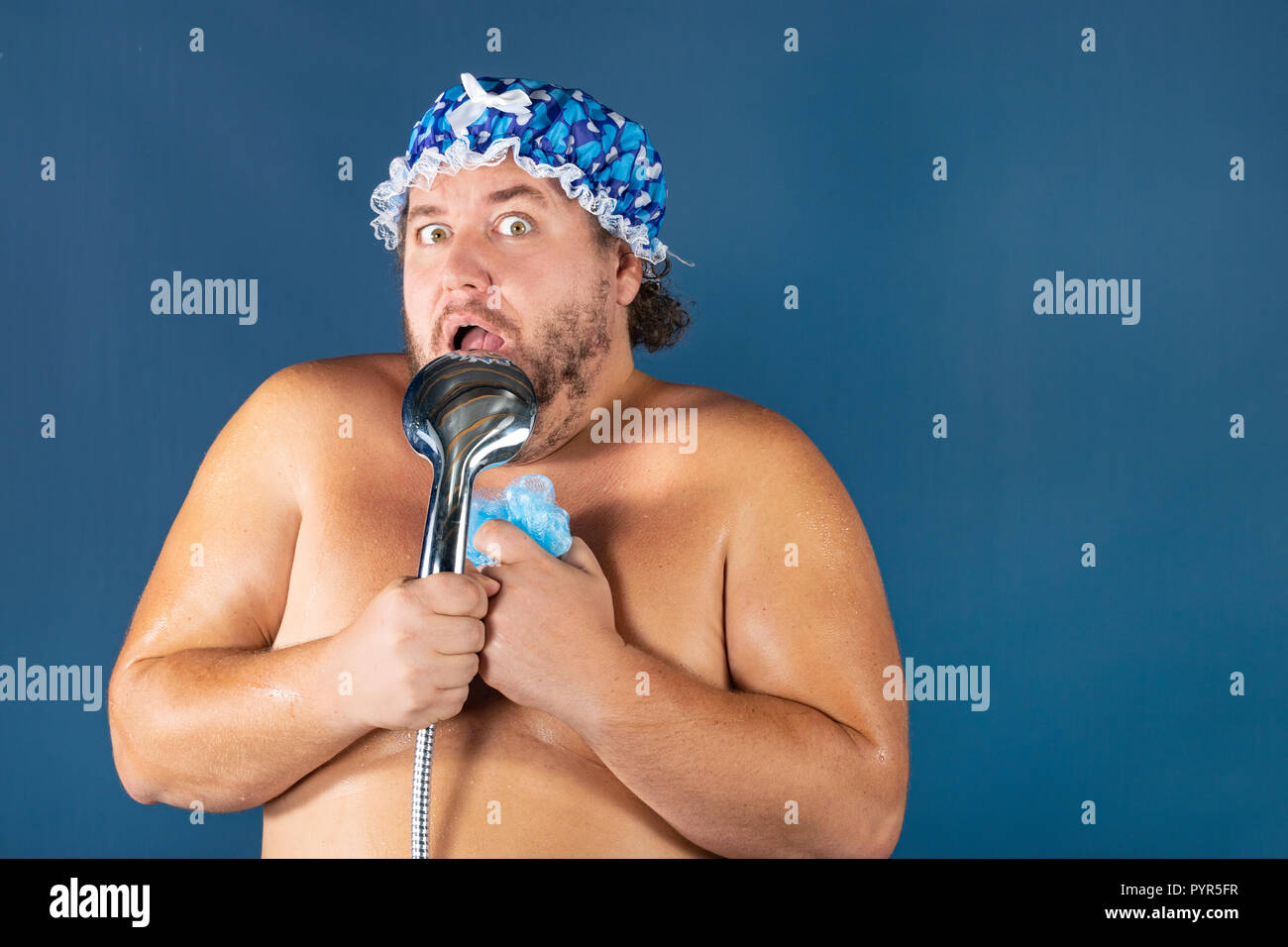 Funny fat man in blaue Kappe Singen in der Dusche. Spaß und Sauberkeit Stockfoto