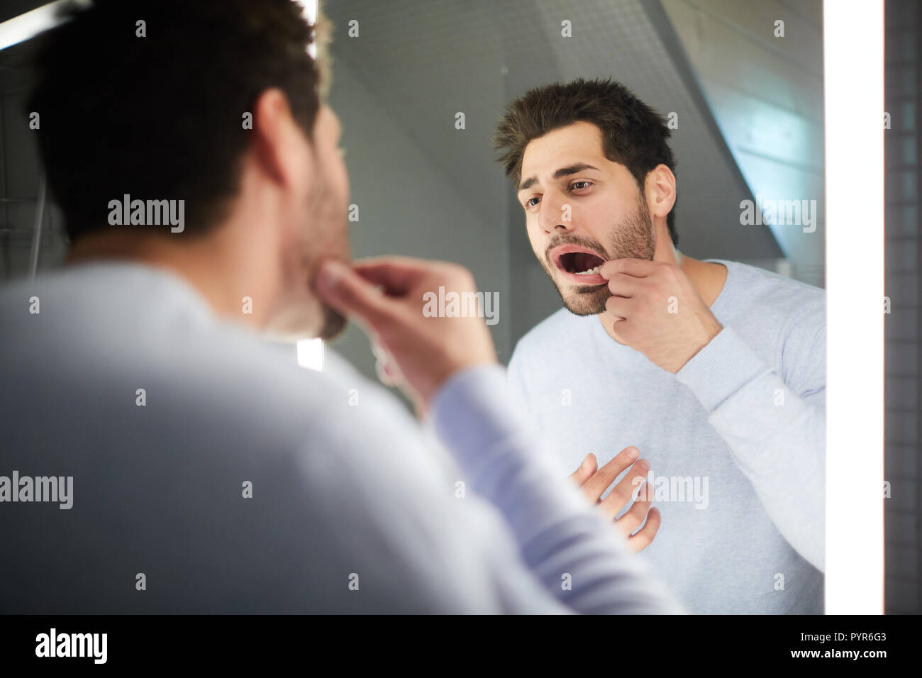 Junger Mann Kontrolle Zahn in Bad Stockfoto