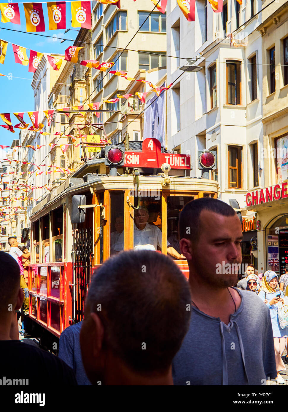 Eine Straßenbahn Überqueren der belebten Istiklal-Straße, geschmückt mit Wimpel der Galatasaray Sports Club. Beyoglu. Istanbul, Türkei. Stockfoto