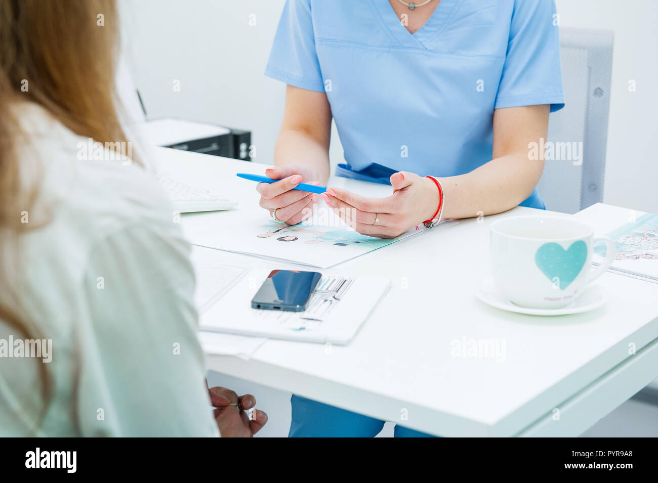 In der Nähe der weiblichen Arzt und Patient an der Rezeption in der modernen Klinik sitzen Stockfoto