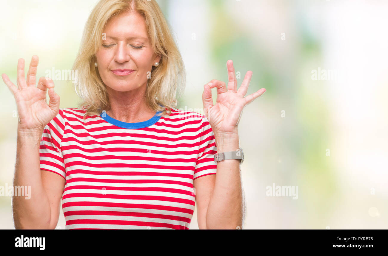 Blonde Frau mittleren Alters über isolierte Hintergrund entspannen und Lächeln mit den Augen dabei geschlossen Meditation Geste mit den Fingern. Yoga Konzept. Stockfoto
