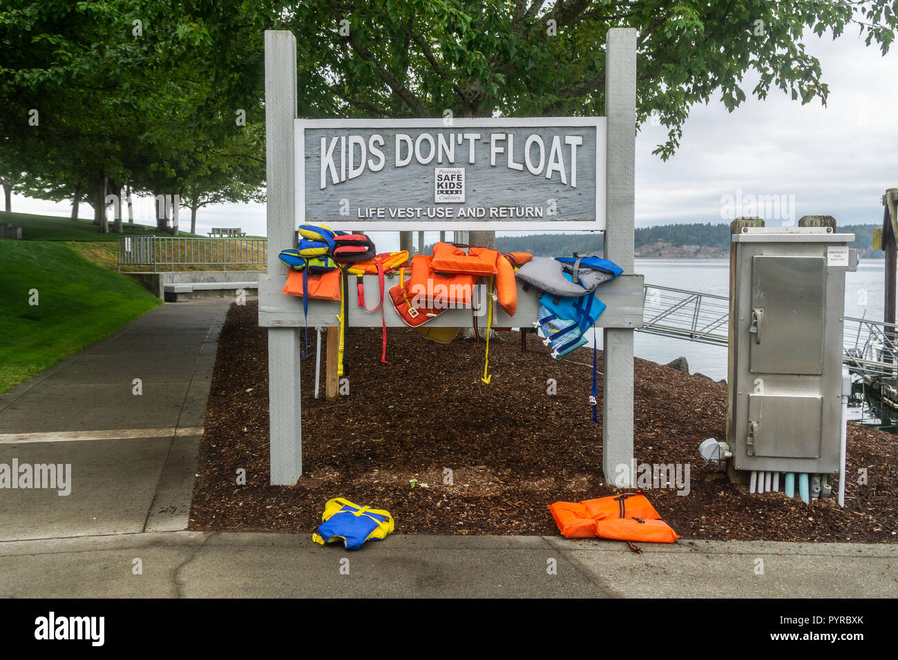 Schwimmweste und Return self service in Sequim Marina mit der Schlagzeile Kinder nicht schwimmen, Washington State, USA. Stockfoto