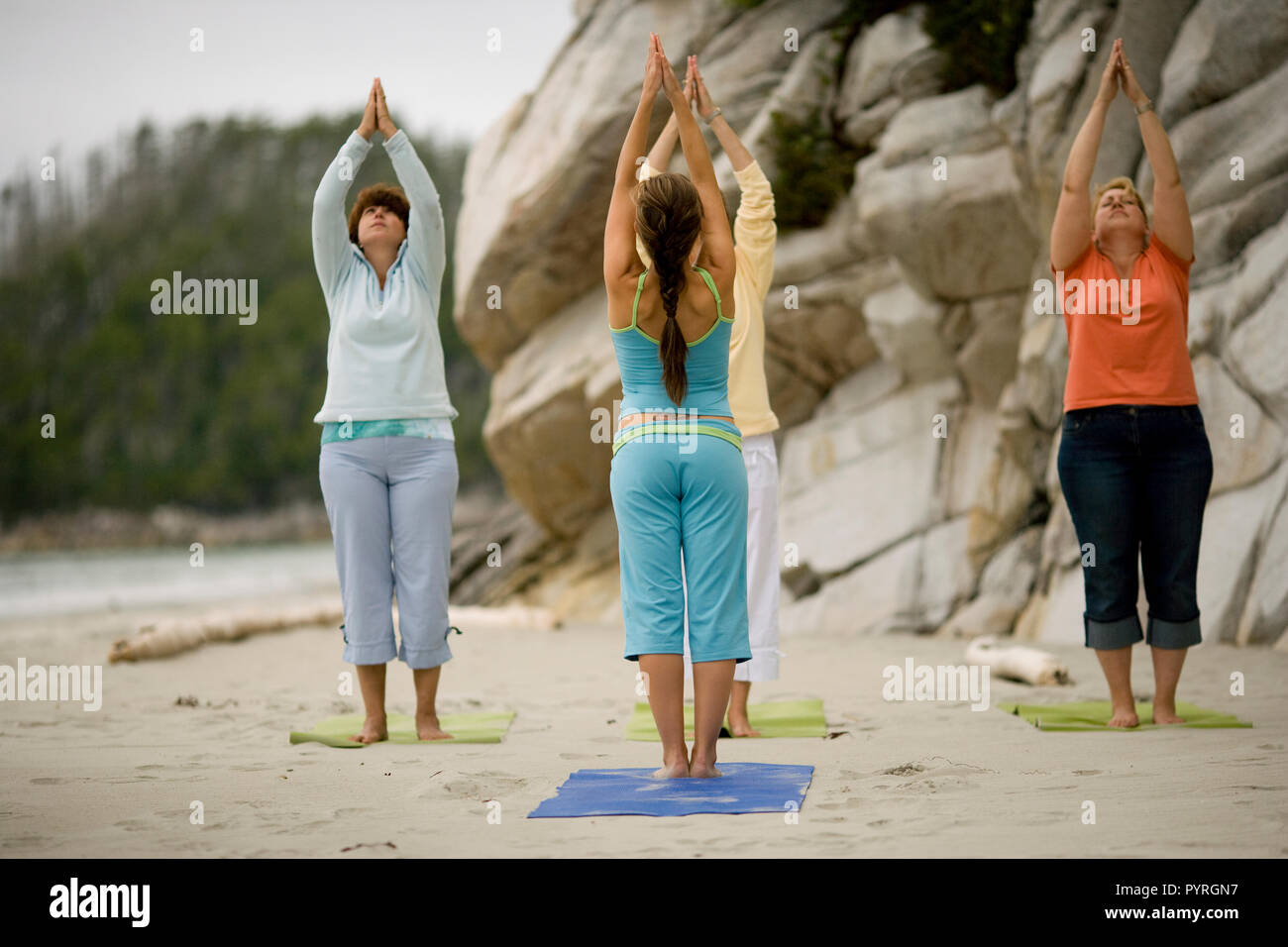 Vier Frau Yoga am Strand. Stockfoto