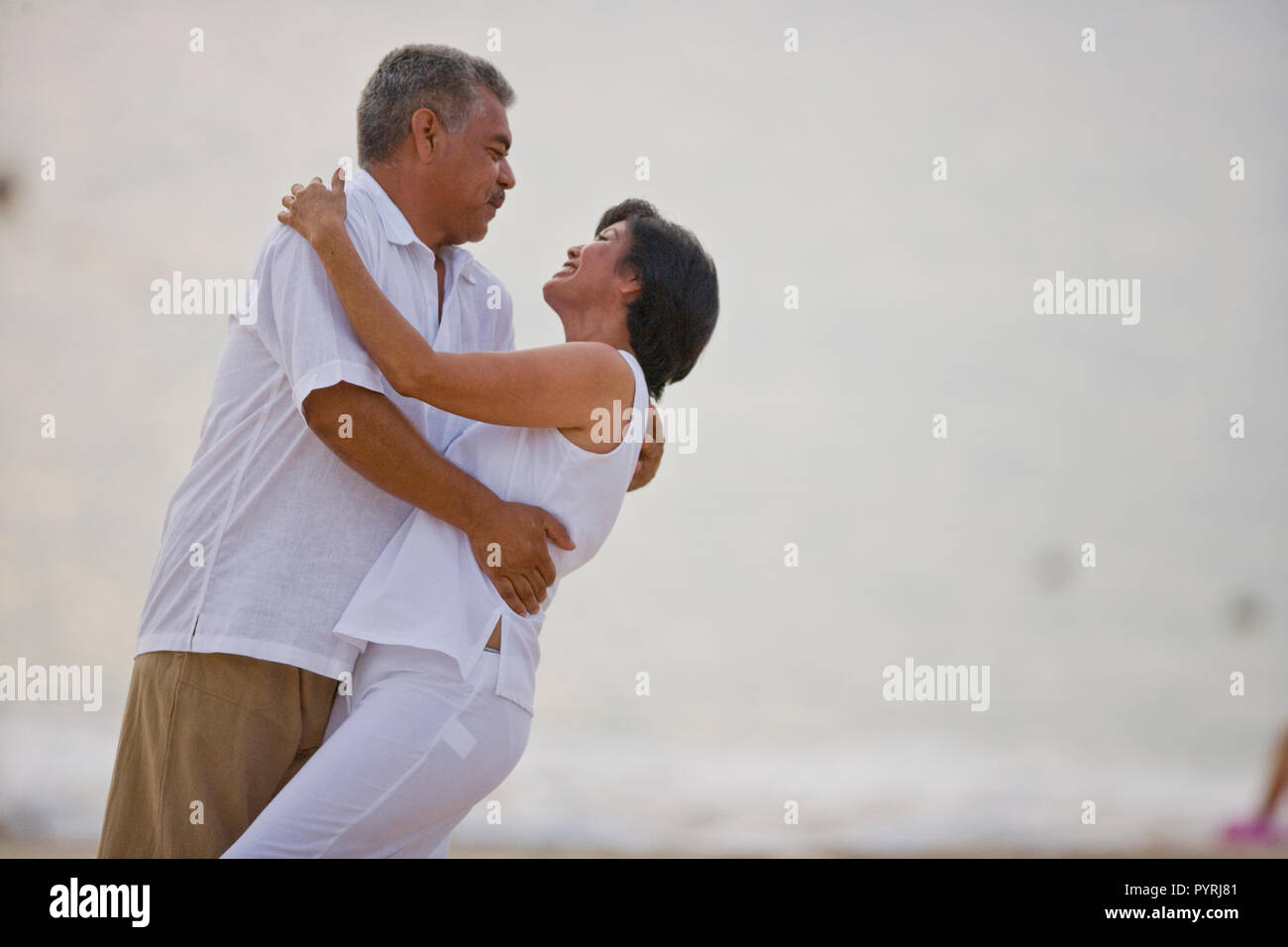 Reifes Paar tanzen am Strand Stockfoto