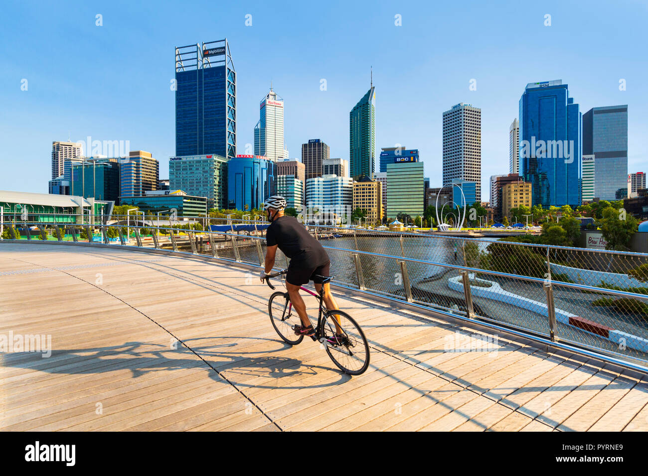Ein Mann Radfahren über Elizabeth Quay Brücke mit Blick auf Perth City im Hintergrund. Elizabeth Quay Stockfoto