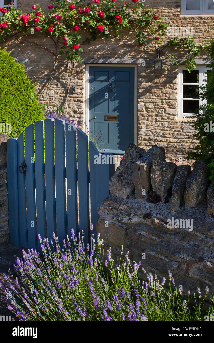 Gateway, die zu Englisch Stein thatch Cottage Garten mit Rosen um Tür, England, Europa Stockfoto