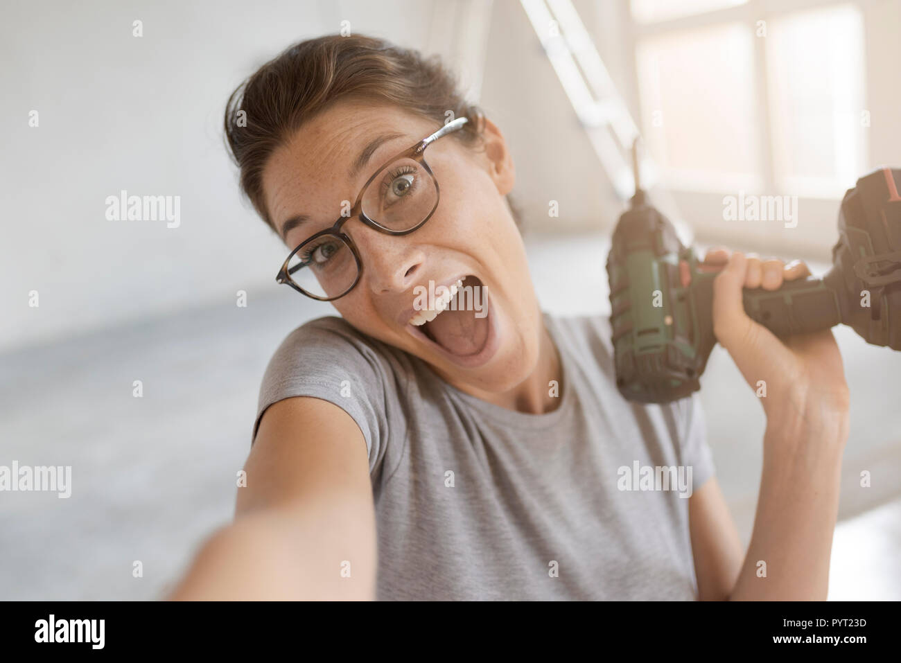 Gerne fröhliche Frau mit einer Bohrmaschine und einem selfie, Home Renovierung und tun es sich Konzept Stockfoto