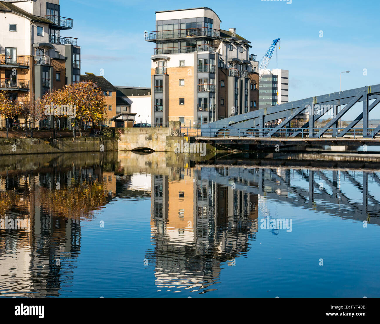 Die moderne Entwicklung Mehrfamilienhaus und Victoria Bügeleisen Drehbrücke in Wasser von Leith Fluss, Ufer, Leith, Edinburgh, Schottland, UK wider Stockfoto