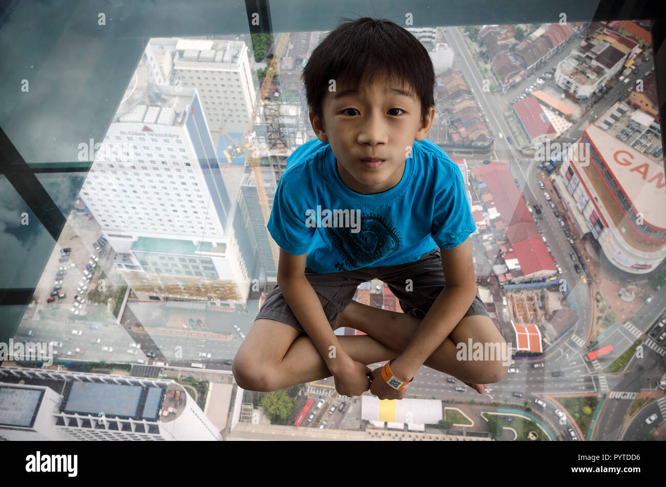 Penang, Malaysia - 27.Juni 2017: Nicht identifizierte Kind sitzen auf Observatory Deck mit transparentem Glas Boden auf Stufe 68 auf dem Dach des Komtar Tower, Pe Stockfoto