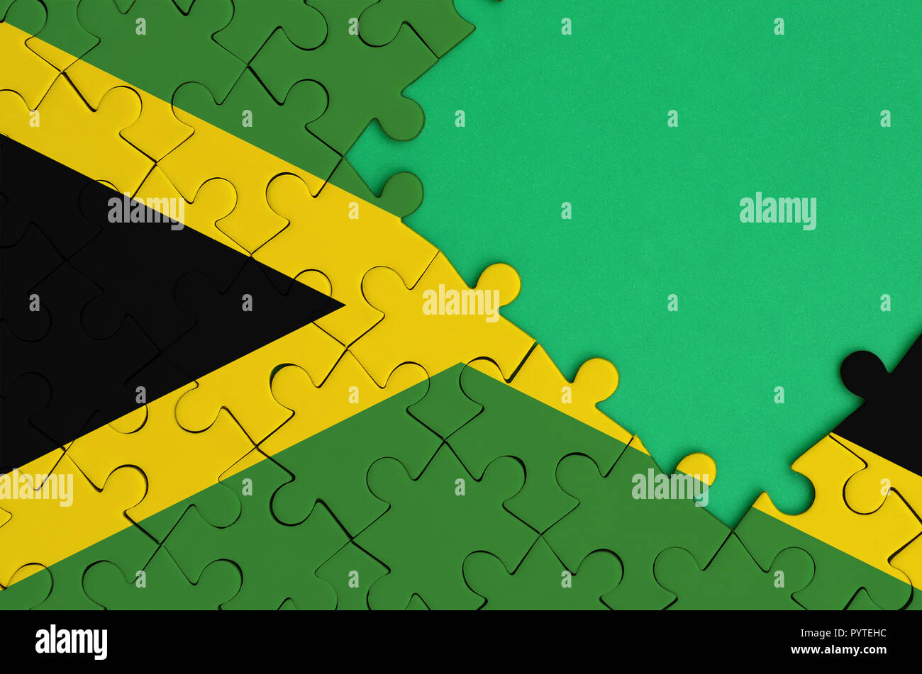 Jamaika Flagge ist auf einer abgeschlossenen Puzzle mit Freie grüne Kopie Raum auf der rechten Seite dargestellt. Stockfoto