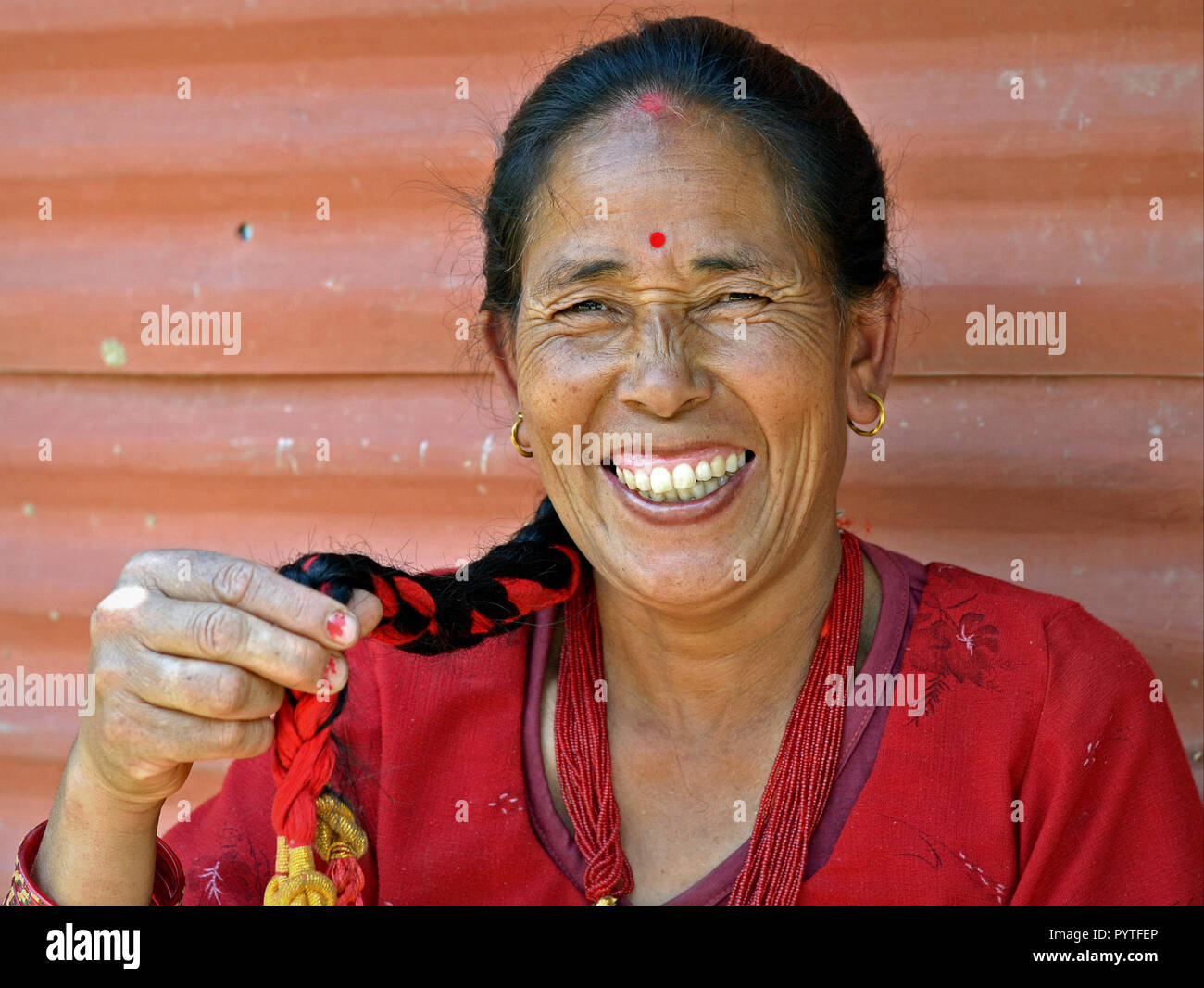 Nepali Brahmane Chhetri Frau von Helambu zeigt ihr langes Haar Zopf und Lächeln für die Kamera. Stockfoto