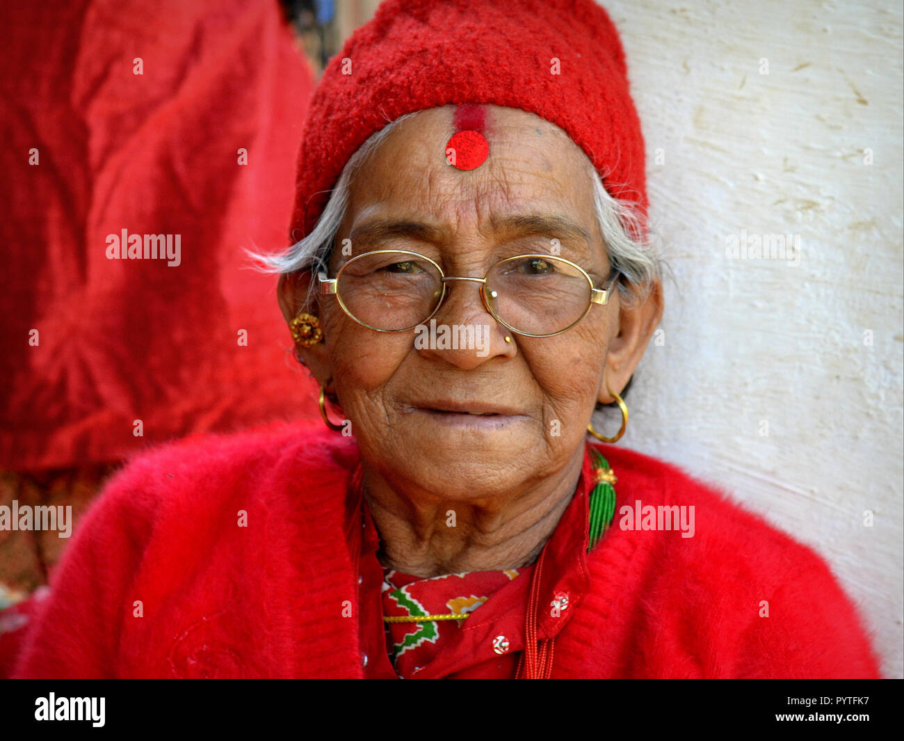 Alte nepalesische Chhetri Frau in Rot, mit einem großen Bindi auf ihrer Stirn. Stockfoto