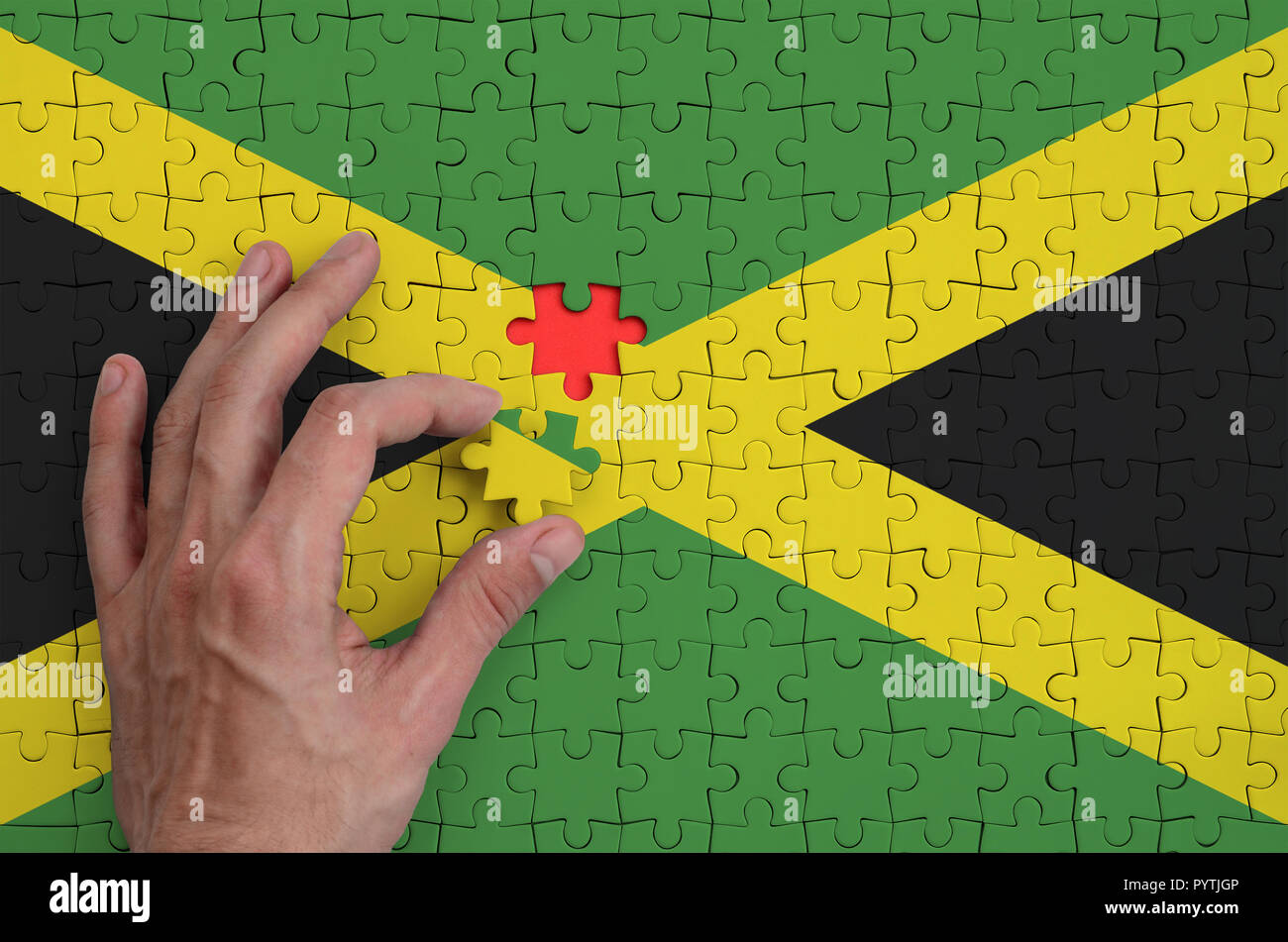 Jamaika Fahne wird auf ein Puzzle, die Hand des Mannes führt zu Falten dargestellt. Stockfoto