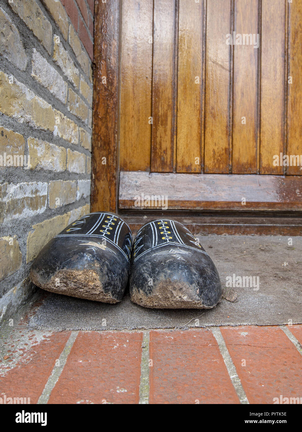 Holzschuhe vor einem braunen farm Tür Stockfoto