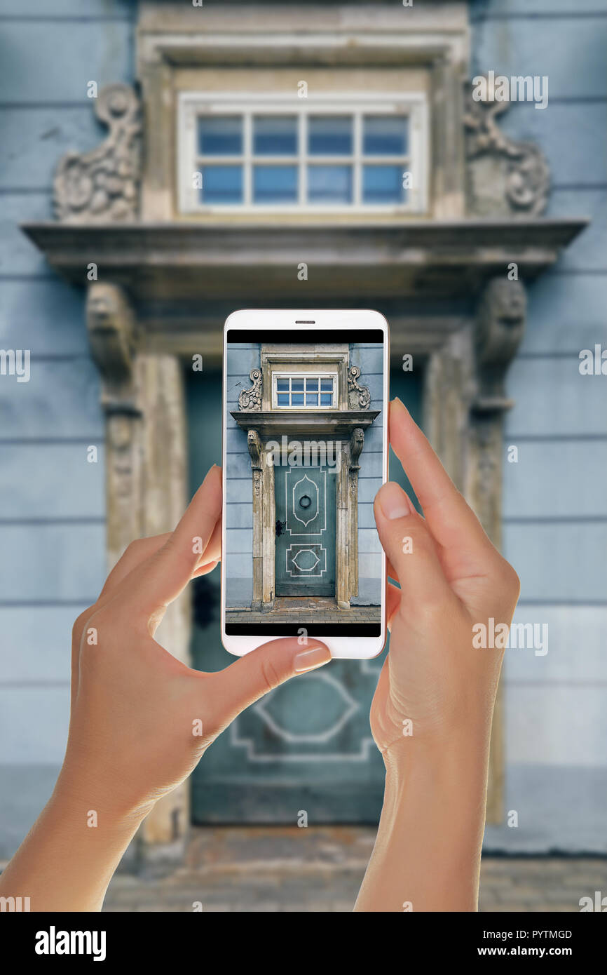 Ein Tourist ist ein Foto des alten blauen Tür mit schönen Säulen, ein Visier und ein Fenster. Altstadt, Riga, Lettland mit einem Mobiltelefon Stockfoto