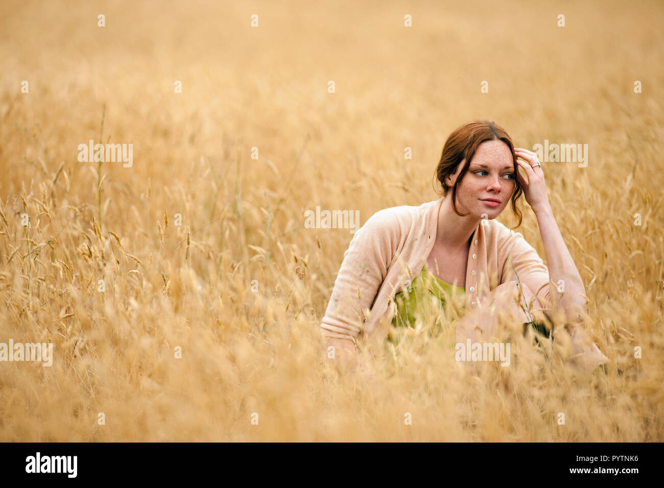 Junges Mädchen genießen sitzen im Weizenfeld. Stockfoto