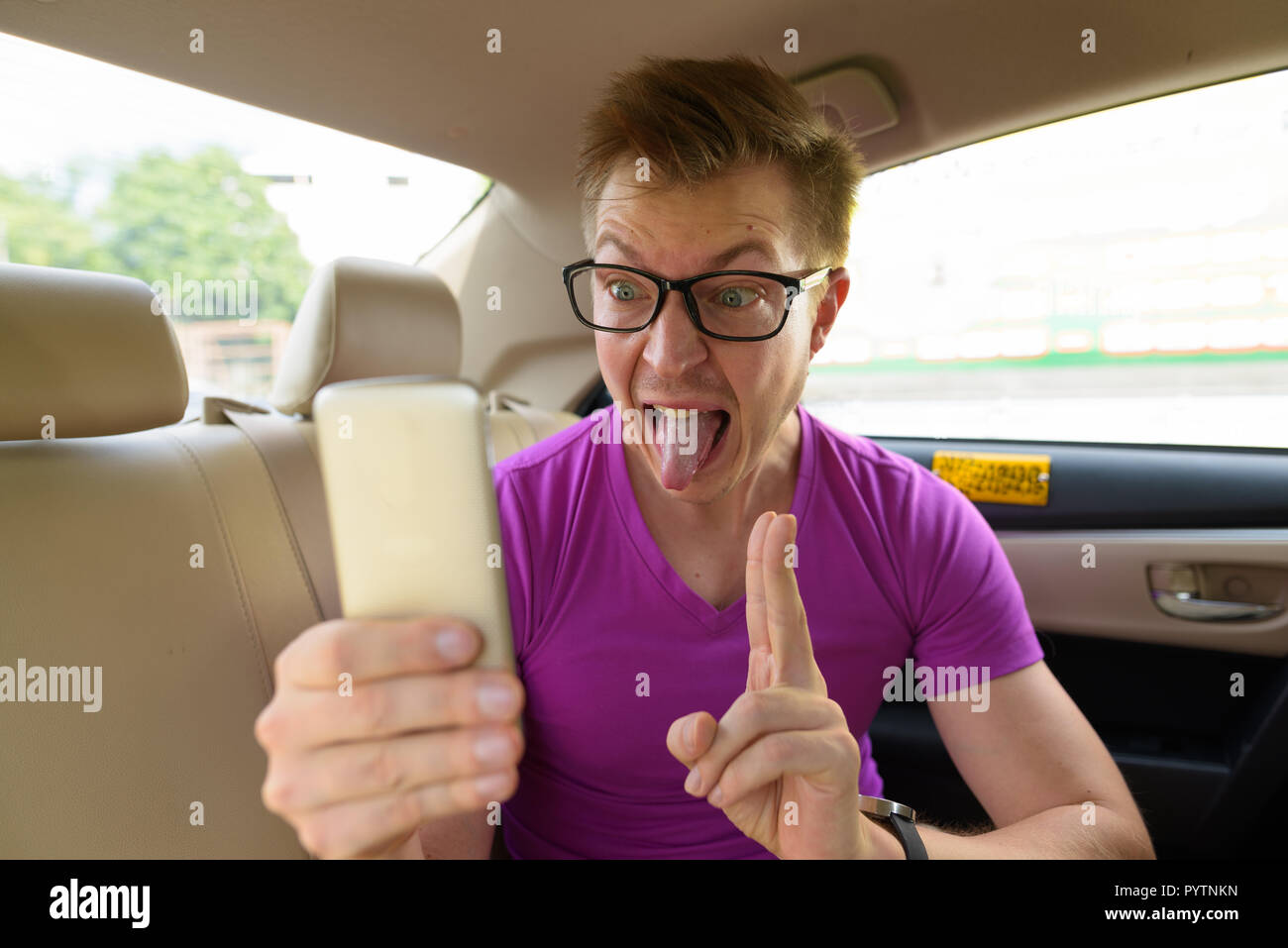 Touristische Mann unter selfie mit Telefon im Rücksitz des Autos Stockfoto