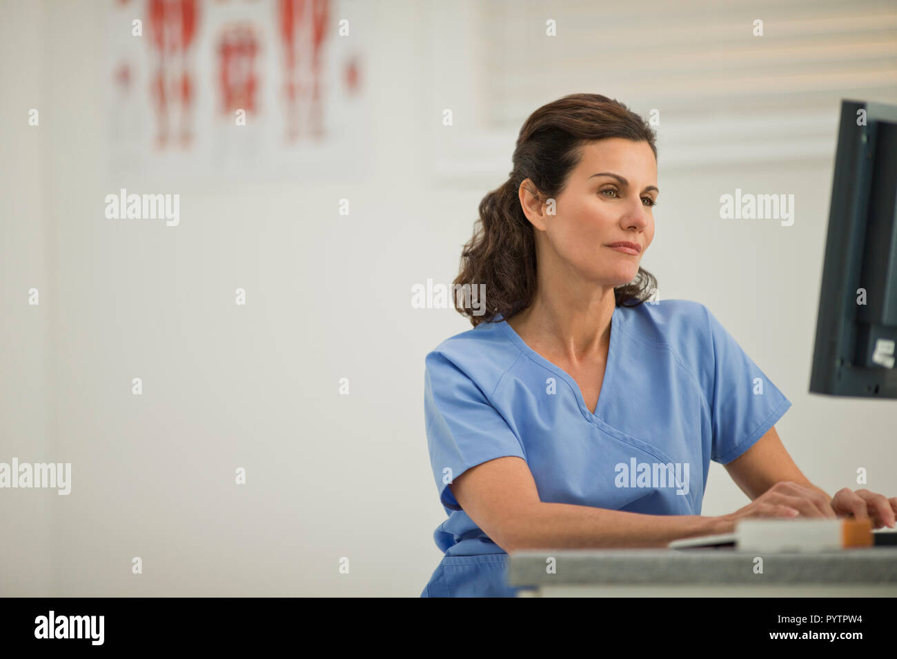 Ärztin mit einem Computer innerhalb einer Arztpraxis. Stockfoto