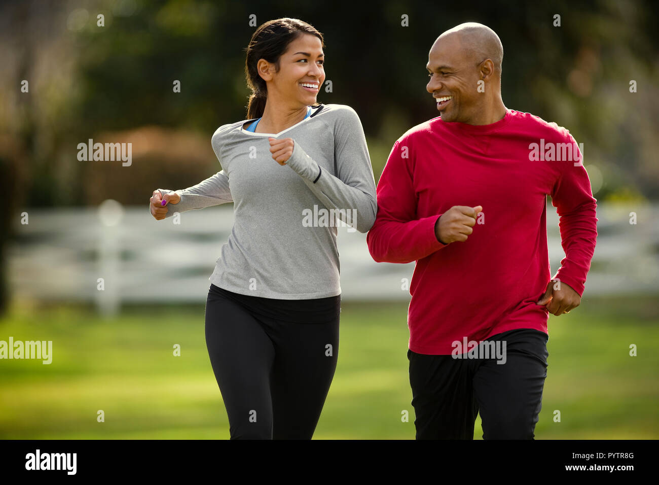 Glückliches junges Paar joggen zusammen in den Park. Stockfoto