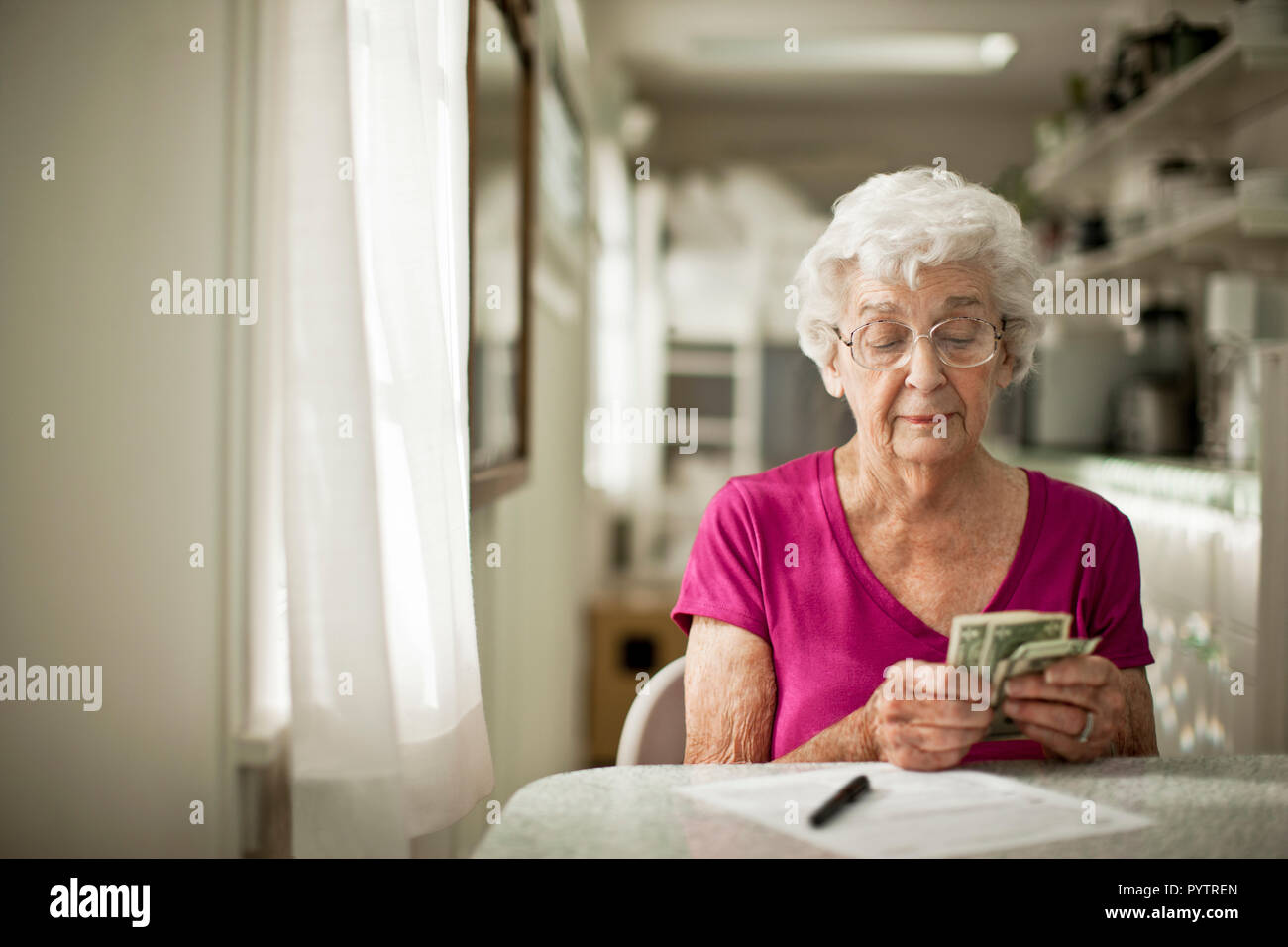 In dem Bestreben, ältere Frau sortiert durch ihr Geld zu sehen, wenn Sie genug die Rechnung vor ihr zu zahlen hat. Stockfoto