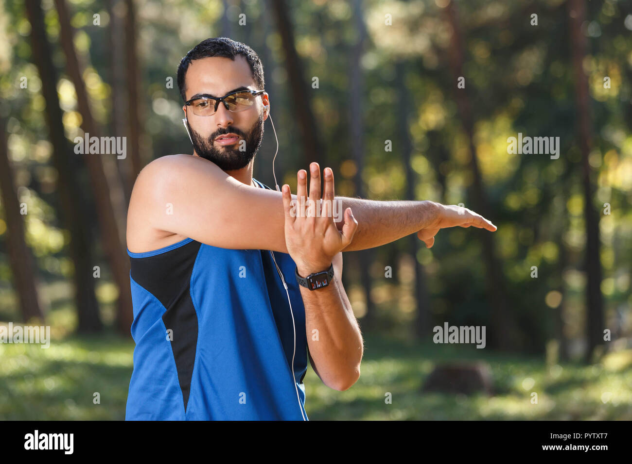Junge athletische multikulturellen bärtigen Mann mit Brille sportish seine Lieblingsmusik hören und Tun seiner Morgengymnastik, gesunden Lebensstil und Personen Konzept Stockfoto