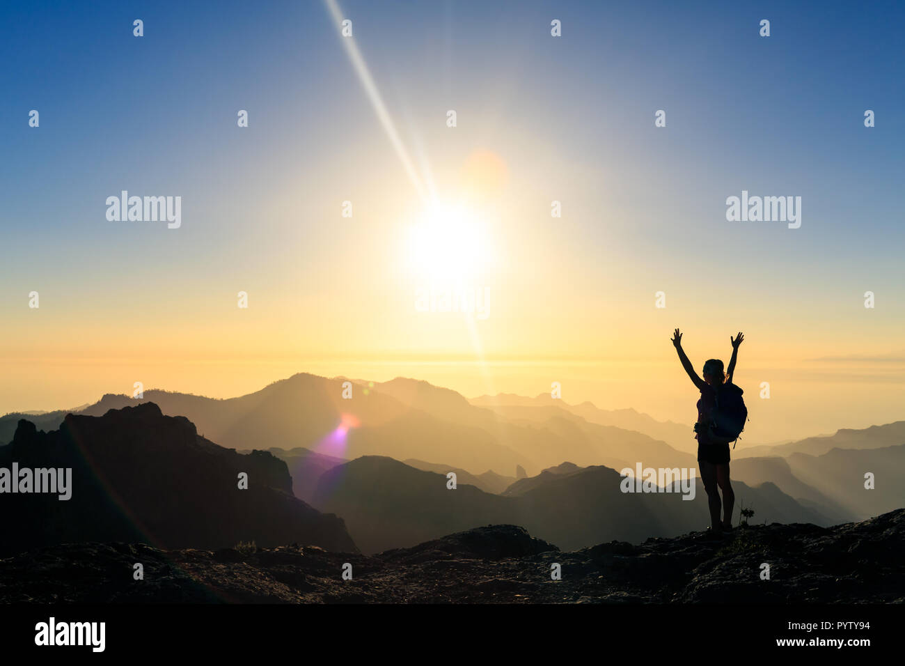 Frau wandern Silhouette in den Bergen, den Sonnenuntergang und das Meer. Weibliche Wanderer mit ausgestreckten Armen auf dem Berg oben Blick auf schöne Nacht Sonnenuntergang inspirat Stockfoto