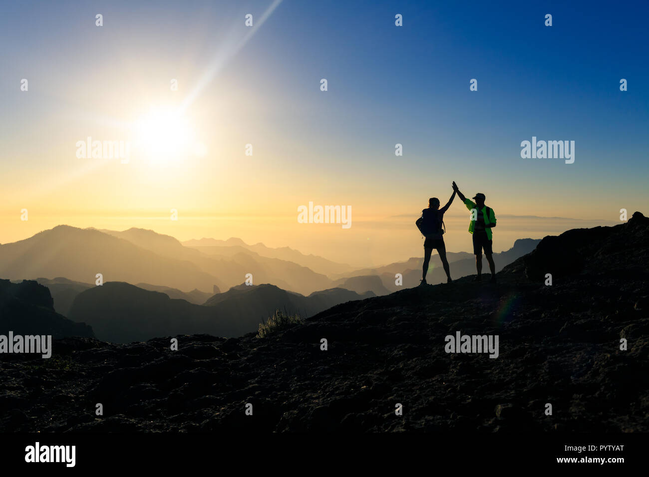 Paar Wanderer Erfolg feiern im Sonnenuntergang in den Bergen, mit Arme ausgestreckt. Junger Mann und Frau auf der Suche nach schöne inspirierende La Stockfoto