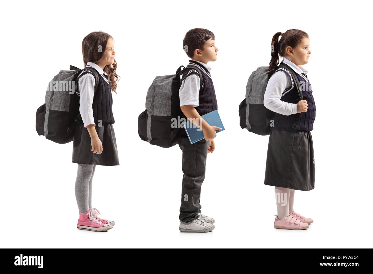 Volle Länge Profil Aufnahme von Schulkindern in Linie auf weißem Hintergrund warten Stockfoto