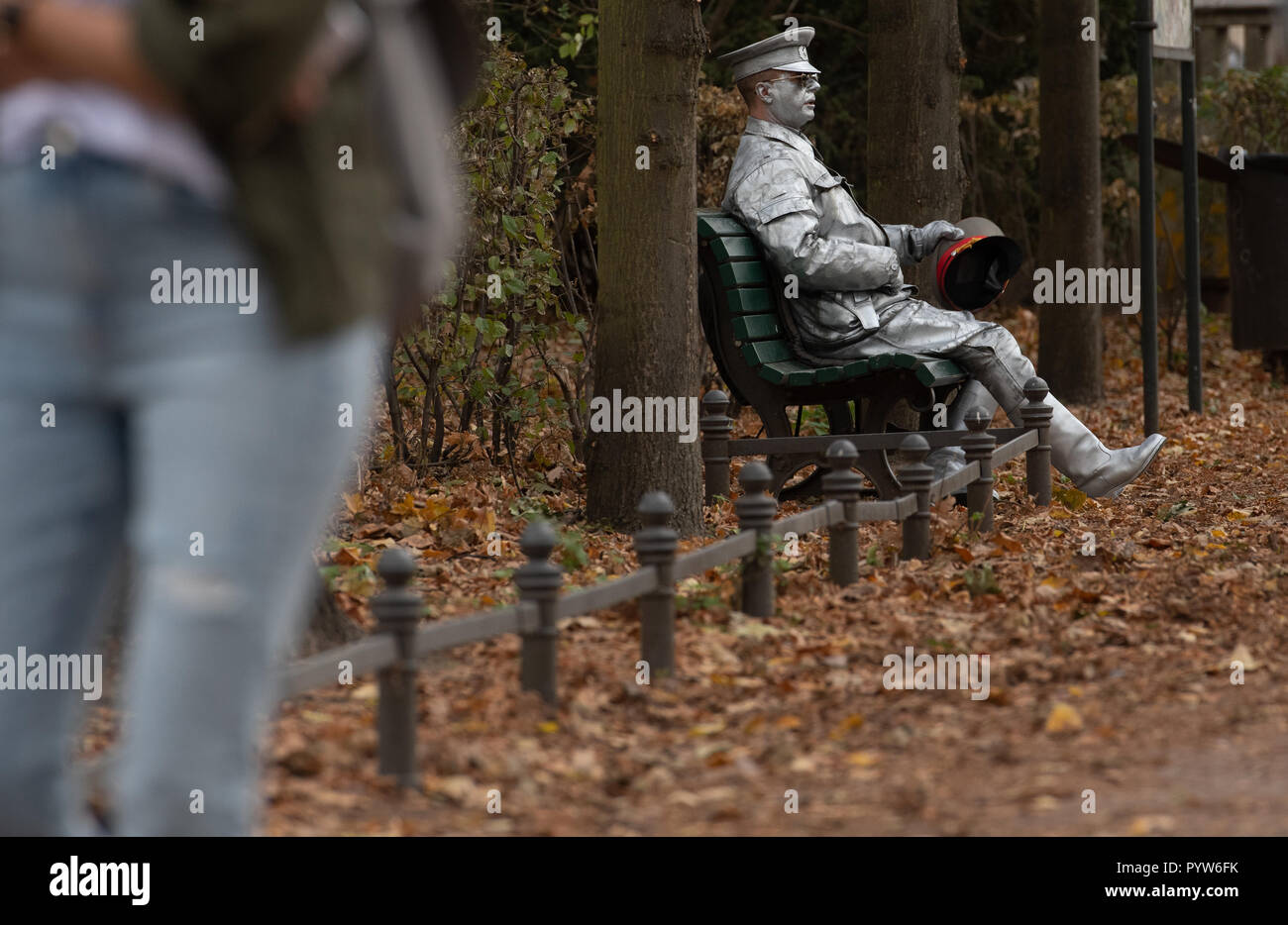 Berlin, Deutschland. 30 Okt, 2018. Eine Straße der Künstler als DDR-Grenzsoldaten getarnt sitzt auf einer Parkbank im Regierungsviertel. Credit: Paul Zinken/dpa/Alamy leben Nachrichten Stockfoto