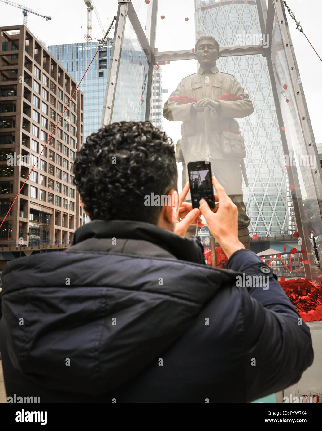 Canary Wharf, London, Großbritannien, 30. Okt 2018. Ein Passant nimmt Fotos der Installation. Jeder erinnert, Jubilee Plaza - Tausende von Mohn durch die Öffentlichkeit in der gesamten Britischen flattern um den Soldaten gewidmet, einer Hommage an alle und jeden für ihre Opfer. Die Erinnerung Art Trail, in Verbindung mit der Royal British Legion, ist kostenlos und kann von der Öffentlichkeit bis zum 11. November in Canary Wharf. ANA (Armee, Marine und Luftwaffe) Credit: Imageplotter Nachrichten und Sport/Alamy Live News besucht werden Stockfoto