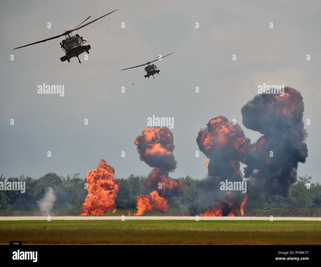 Militärhubschrauber in Boden Angriff mit Explosionen Stockfoto
