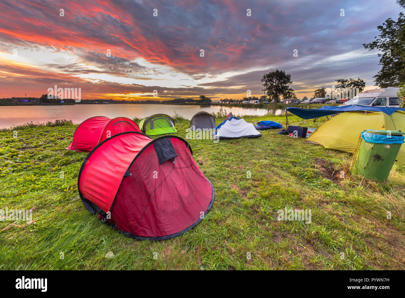 Campingplatz mit Dome Zelte in der Nähe von See auf ein Musik Festival camp site unter schönen Sonnenaufgang Stockfoto