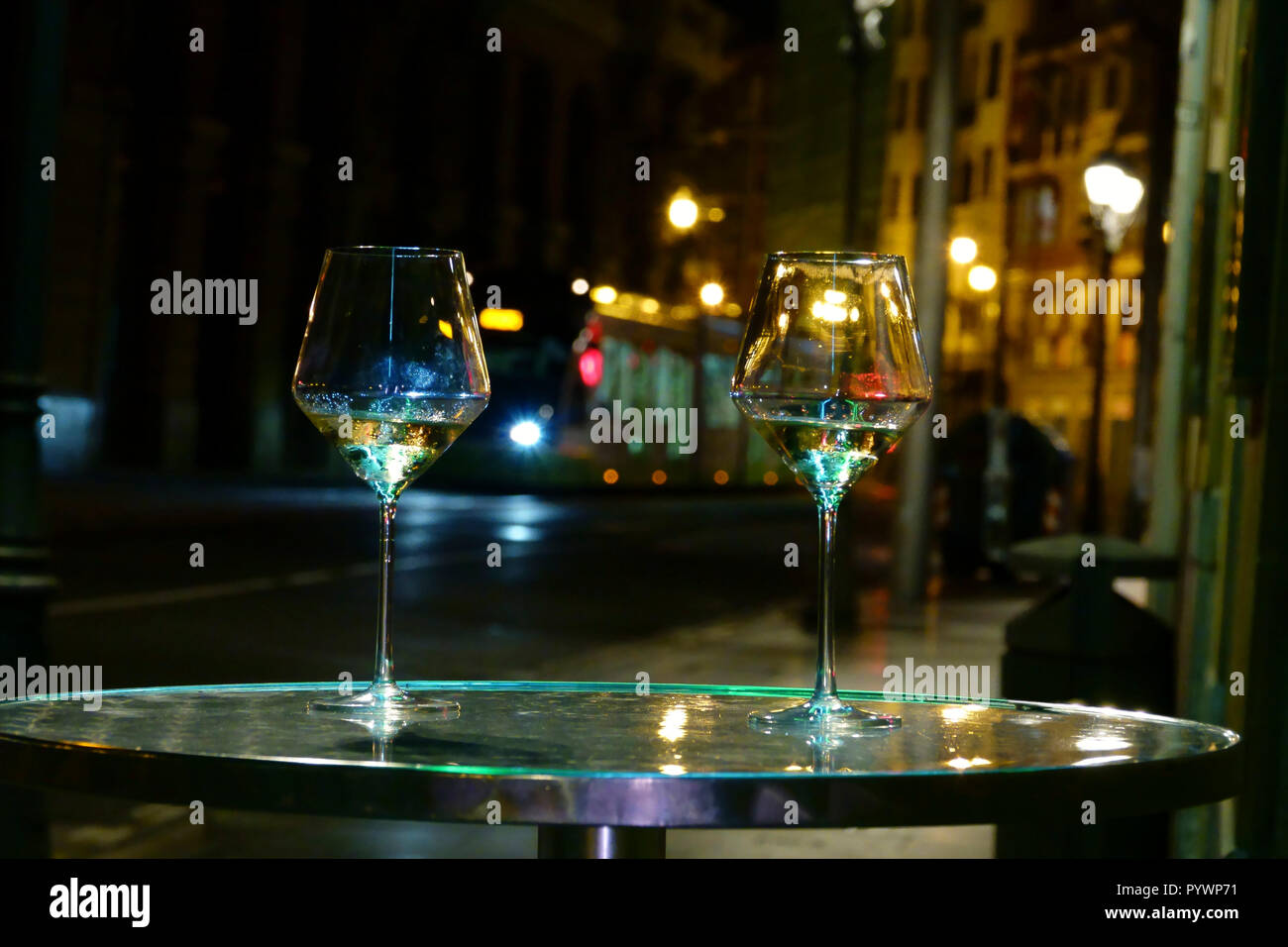 Bilbao, Baskenland, Spanien zwei Weingläser hinter sich gelassen in die glitzernden Lichter der Stadt Nachtleben Stockfoto